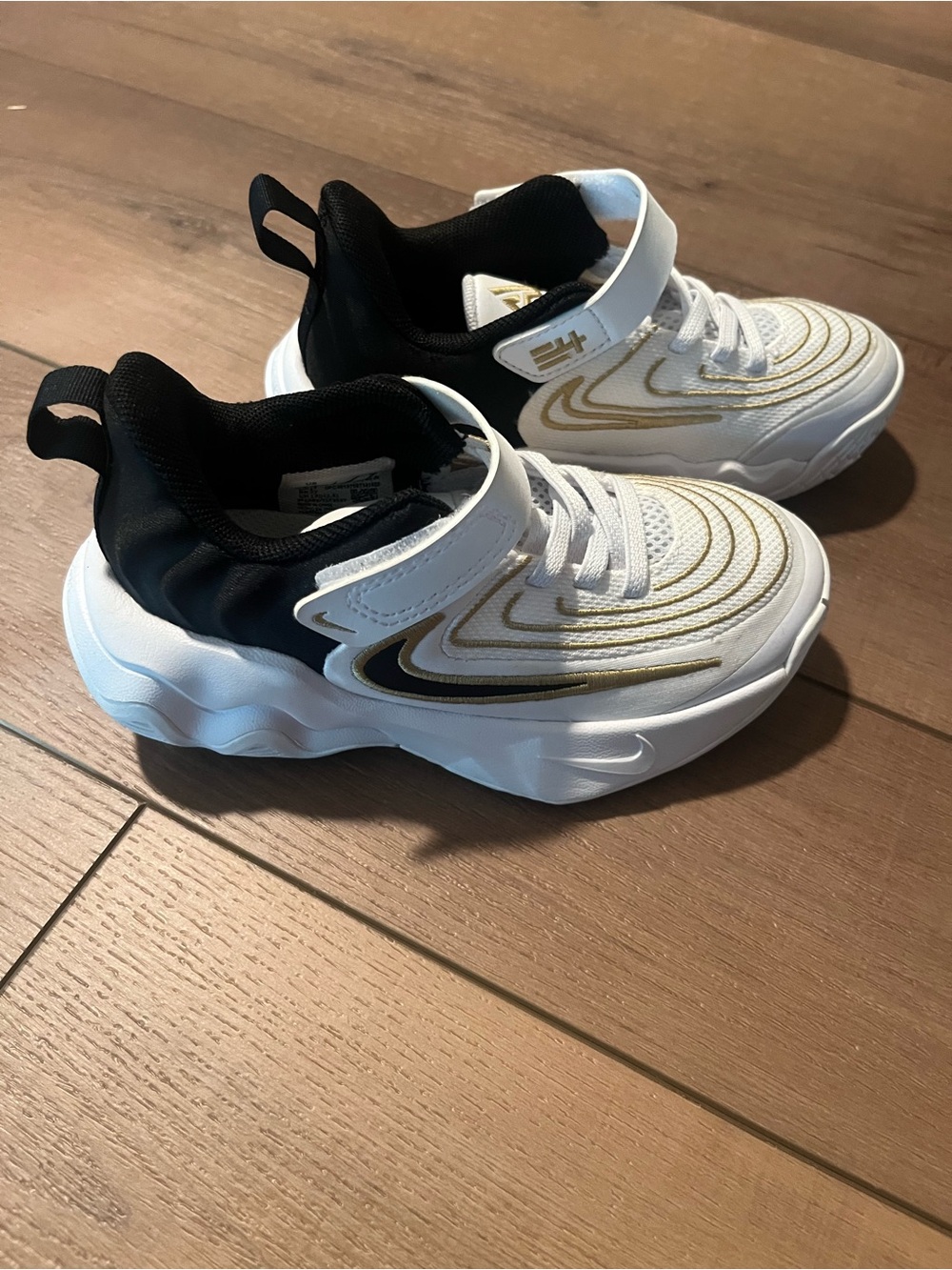 Nike White and Black Athletic Sneakers with Gold Accents. Basketball Shoes